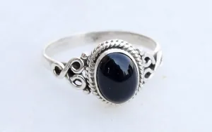 Close-up macro view of vintage silver ring featuring a polished oval black onyx stone