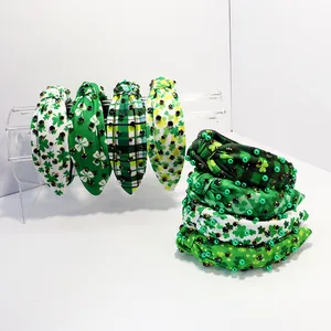 Detailed view of St. Patrick's Day knotted headbands with clover prints and rhinestones