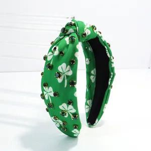 Detailed view of green shamrock printed knotted headband with sparkling rhinestones