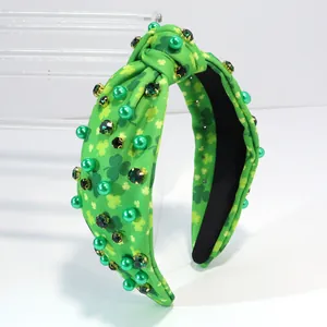 Detailed shot of green shamrock knotted headband with sparkling emerald crystals and pearls
