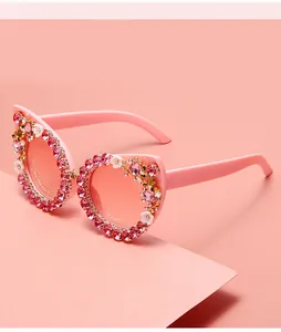 Detailansicht der rosa Katzenaugen-Sonnenbrille mit Strass- und Blumenverzierung