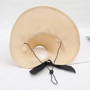 Un elegante sombrero de paja plegable con ala ancha y un lazo negro para playa