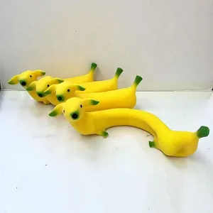 Detailansicht von vier dehnbaren gelben Bananen-Hund-Quetschspielzeugen auf Weiß