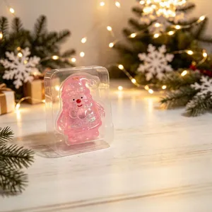 Detailansicht eines rosa glitzernden Weihnachtsmann-Kristallschmucks in Weihnachtsverpackung