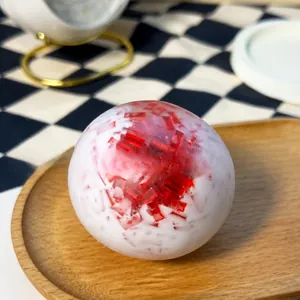 Handmade squishy stress relief toy ball with red ice shard texture on wooden plate