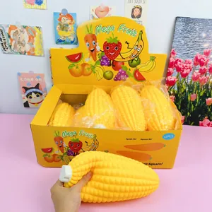 Primer plano de una mano apretando un gran juguete squishy con forma de maíz de 33 cm