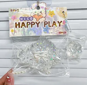 Gros plan d'un jouet squishy en forme de croissant transparent avec perles et étoiles.