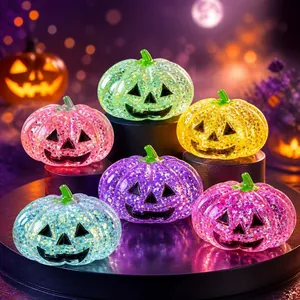 Macro view of colorful glitter Halloween pumpkin squishy toys with glowing effects