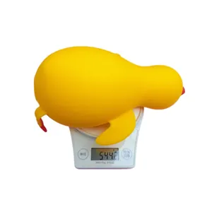 Gran pato amarillo de 33 cm antiestrés de rebote lento, pesando 544g en una báscula.