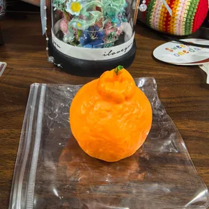 Realistic orange-shaped handmade squishy toy for stress relief on a desk.