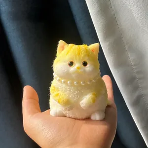 Vue rapprochée d'un jouet anti-stress chat jaune réaliste avec collier de perles en main