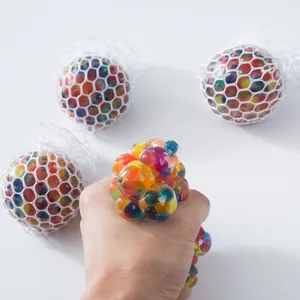 Close-up of a hand squeezing a colorful mesh grape stress ball for anxiety relief
