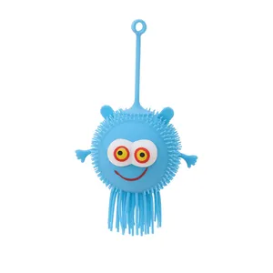 Pallina giocattolo in gomma blu con punte, faccia sorridente e lunghi tentacoli vista