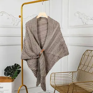 Detailansicht eines gestrickten dreieckigen Schal-Ponchos mit stilvoller Lederschnalle