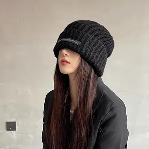 Close-up detail of the black chunky knit beanie on a model for a warm winter look.