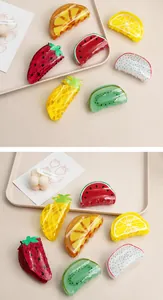 Detail view of vibrant acetate hair claw clips in various fruit shapes like strawberry.