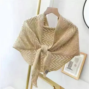 Nahaufnahme eines beigefarbenen Strickschals mit elegantem Zickzack-Lochmuster