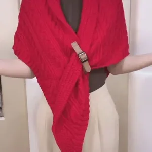 Nahaufnahme des roten Strickschals mit stilvoller brauner Gürtelschnalle als Detail