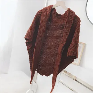 Detailaufnahme eines braunen Strickschals mit dekorativer Wellenstruktur