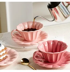 Elegantes rosa keramik kaffeetassen set in blütenform mit eingegossenem kaffee.