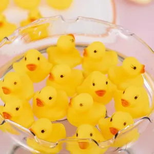 Close-up of multiple cute yellow rubber ducks floating in clear water for baby bath time
