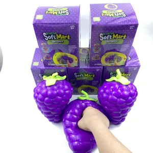 Detailed view of a giant purple grape squishy stress relief toy being squeezed by hand