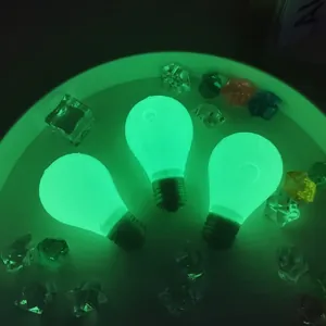Primo piano di tre giocattoli antistress a forma di lampadina che brillano di verde al buio