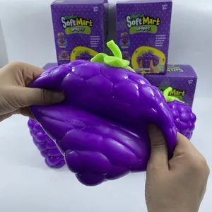 Close-up view of a large purple grape squishy toy being stretched for stress relief.