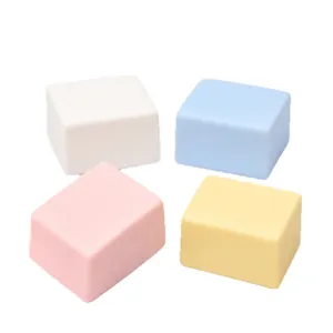 Set of four colorful square squishy toys in pastel pink, blue, yellow, and white