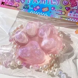 Detail of pink glittery cat paw squishy toy in original retail packaging