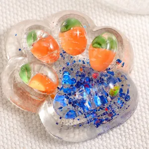 Macro de un juguete squishy pata de gato transparente con zanahorias y purpurina azul