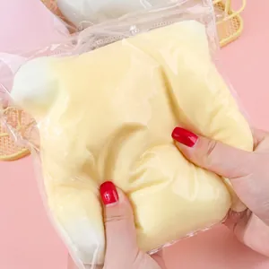 Close-up of a hand squeezing a large pale yellow fluid stress relief squishy toy