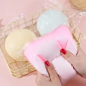 Close-up of a pink fluid-filled stress ball toy being squeezed by hand