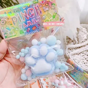 Détail du jouet anti-stress en peluche patte de chat dans un emballage bleu et blanc