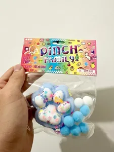 Détail d'un jouet anti-stress patte de chat coloré dans un emballage avec pompons