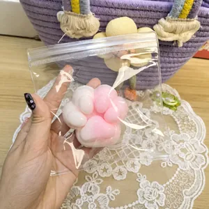 Λεπτομερής προβολή ροζ και λευκού squishy παιχνιδιού πατούσας γάτας σε διάφανη συσκευασία