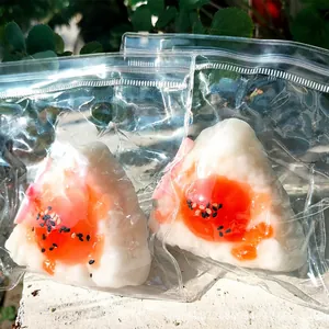 Two realistic onigiri rice ball squishy toys in clear packaging with slow rebound texture