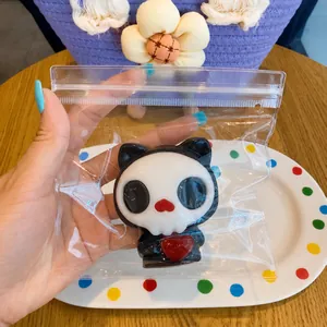 Detailed view of soft TPR Halloween skull squeeze toy with a red heart in clear packaging