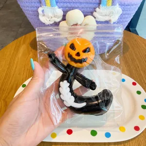 Detail showing a Halloween pumpkin head squishy stress relief toy in clear plastic packaging