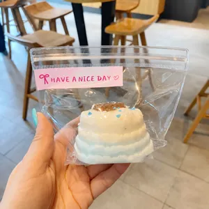 Close-up of a realistic Basque cheesecake squishy toy inside a clear zipper packaging bag