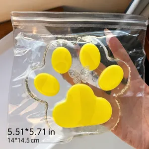 Primer plano de un juguete squishy gigante de pata de gato amarilla de 14 cm en su empaque