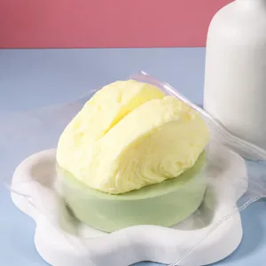 Detail view of a simulation Basque cheesecake squishy toy in clear packaging on a white tray