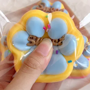 Gros plan d'un jouet squishy en forme de patte de chat jaune et bleu texture souple