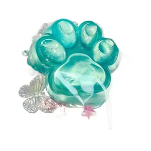 Close-up of a translucent teal cat paw squishy toy decorated with sparkling glitter.