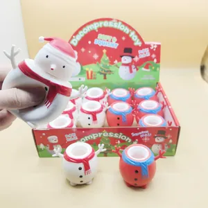 Gros plan d'une main pressant un jouet anti-stress bonhomme de neige de Noël en détail