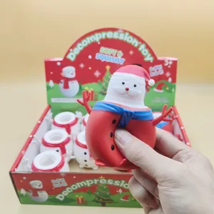 Gros plan d'une main pressant un jouet de décompression souple Père Noël pour enfants
