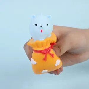 Gros plan d'un jouet squishy ours bleu pressé dans un sac de chance orange vif