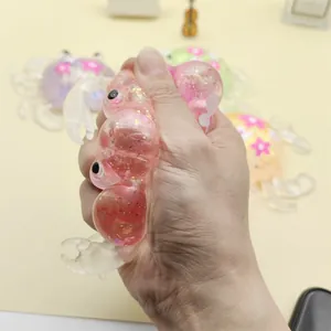 Close-up detail of hand squeezing a pink maltose crab squishy toy with glitter filling