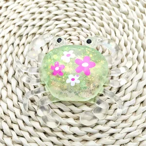 Detailed macro view of a green glitter crab squeeze toy with pink flower patterns