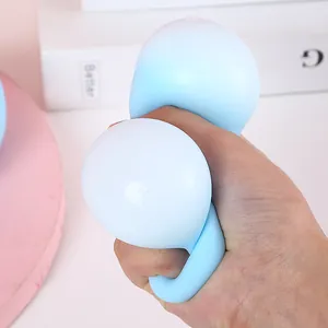 Blue and white gradient moon squishy toy for stress relief being squeezed by hand